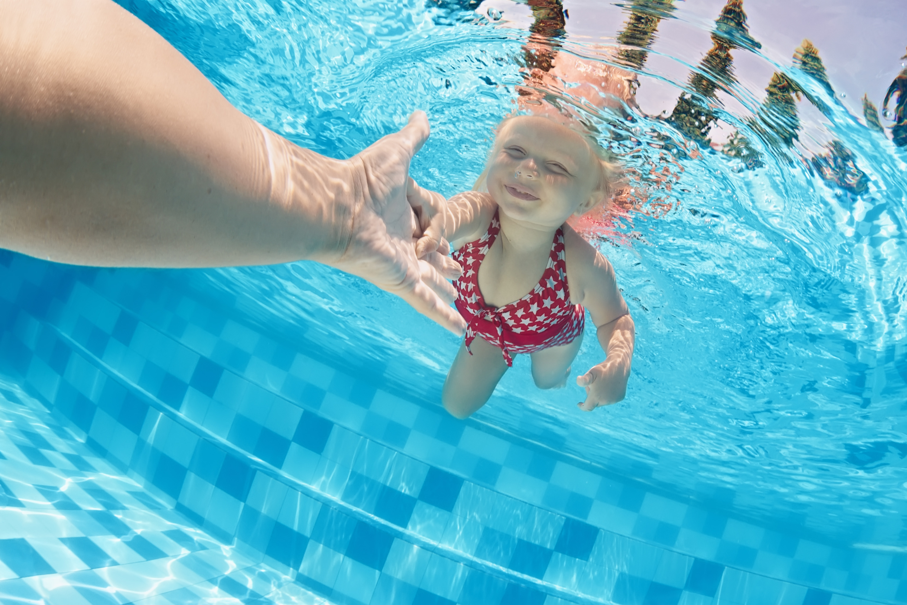 child-swimming-underwater-in-the-pool-with-parents-splash-swim-school